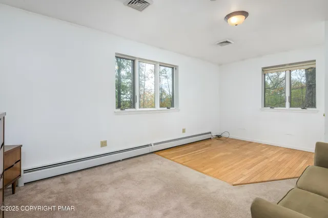 a living room with furniture and a large window with garden view
