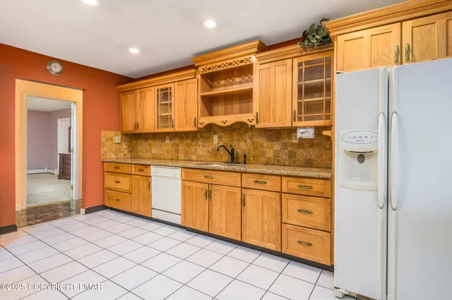 a kitchen with granite countertop cabinets and white appliances
