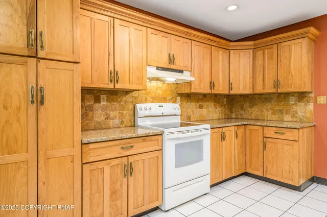 a view of empty room with kitchen view and a window