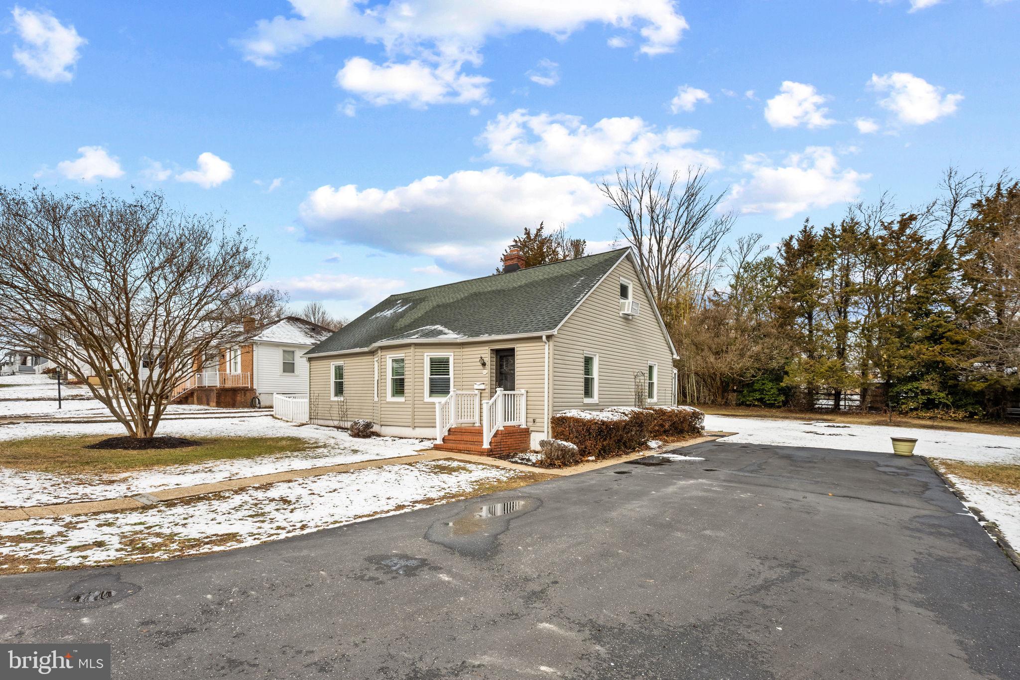a view of a house with snow on the side of the road