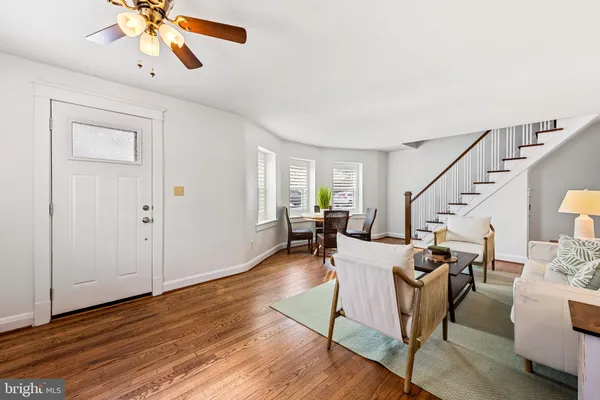 a living room with couches chairs and closet with wooden floor