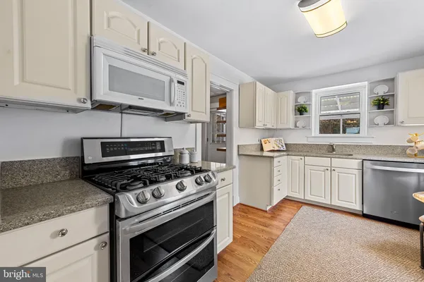 a kitchen with stainless steel appliances a stove a microwave and cabinets