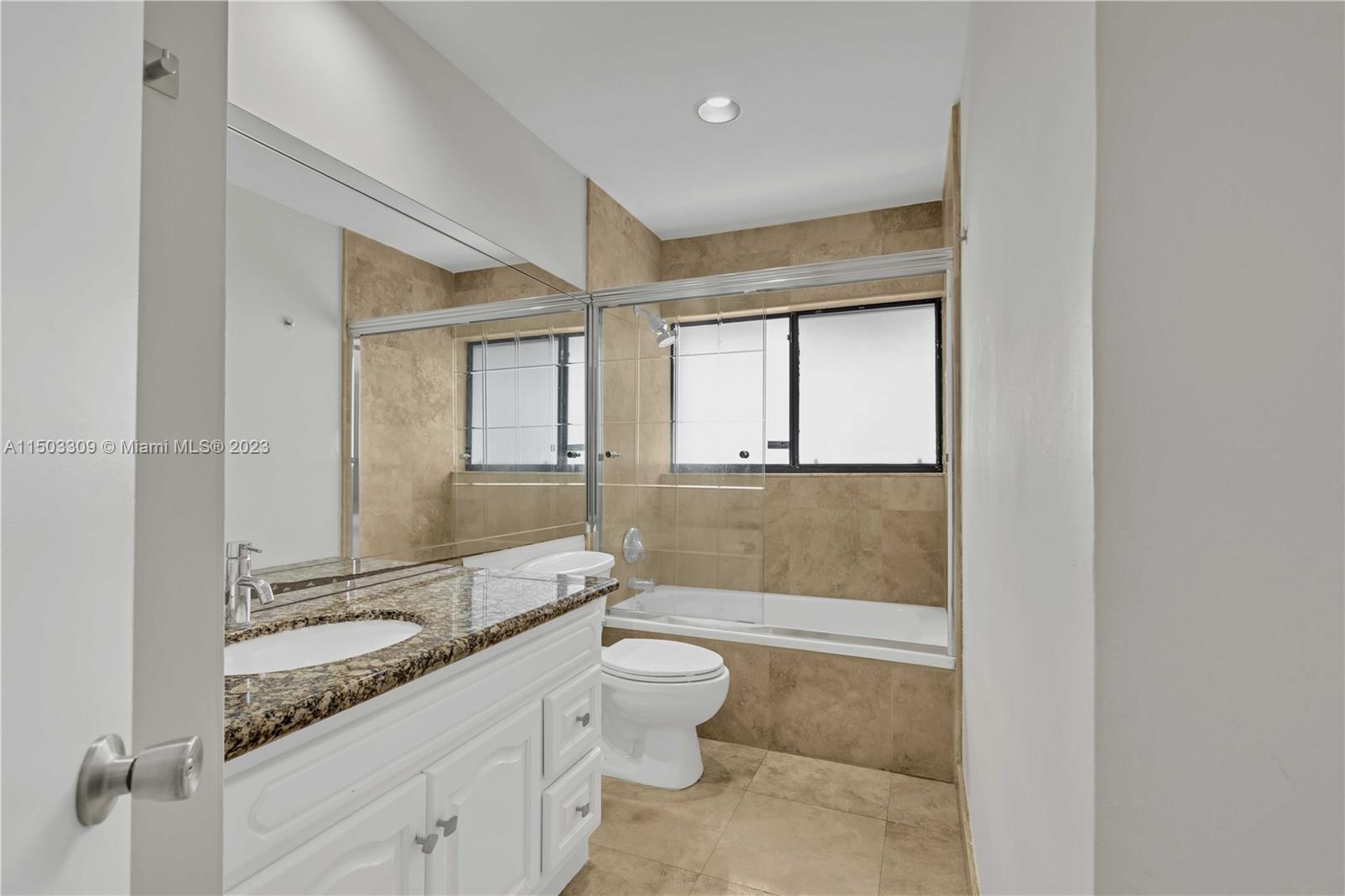 6242 Sweet Maple Lane Boca Raton, FL 33433 - Photo 11 of 31 a bathroom with a granite countertop sink a toilet and bathtub
