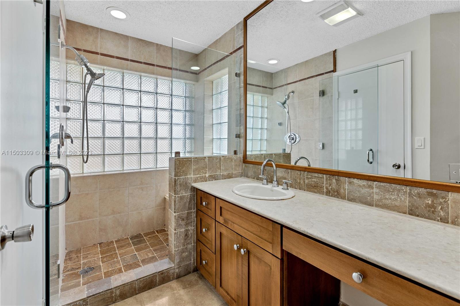 6242 Sweet Maple Lane Boca Raton, FL 33433 - Photo 17 of 31 a bathroom with a shower sink and mirror
