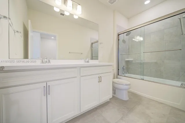 a bathroom with a toilet a sink and a large mirror