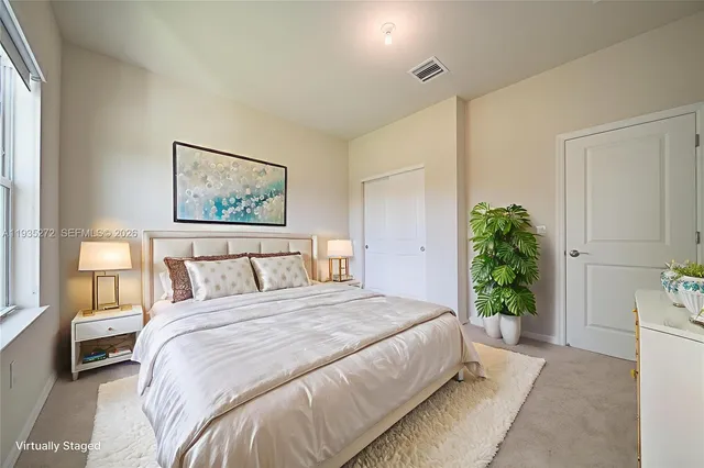 a bedroom with a large bed and a potted plant