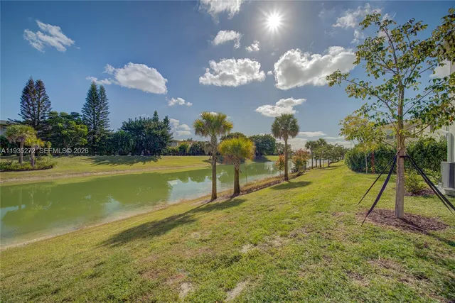 a front view of a house with a yard and potted plants