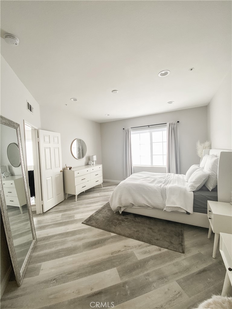 151 Islington Irvine, CA 92620 - Photo 11 of 15 a spacious bedroom with a large bed a mirror and a window