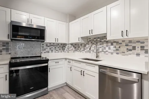 a kitchen with cabinets stainless steel appliances and a sink