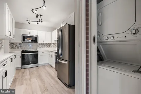 a kitchen with stainless steel appliances a refrigerator sink and cabinets