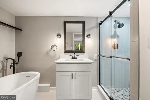 a bathroom with a granite countertop sink a toilet and shower