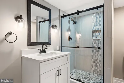 a bathroom with a shower sink and mirror
