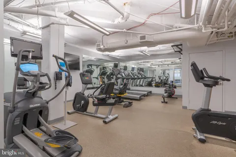 a dining room with furniture large windows and wooden floor