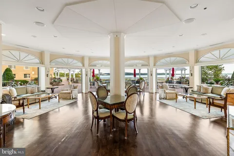 a view of a dining room with furniture a chandelier and wooden floor