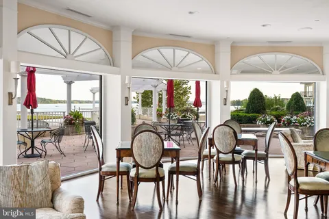 a living room with furniture kitchen view and a wooden floor
