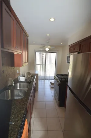 a kitchen with a sink a refrigerator and wooden cabinets