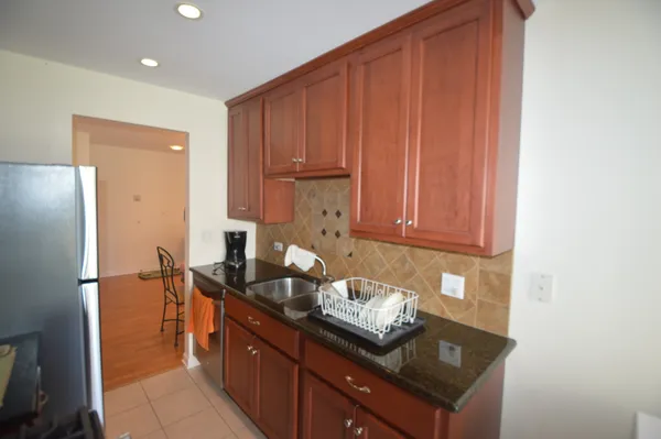 a kitchen with granite countertop wooden cabinets and a stainless steel appliances