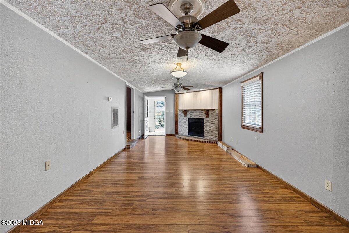 5682 Hartley Bridge Road Macon, GA 31216 - Photo 12 of 79 a view of empty room with wooden floor and ceiling fan