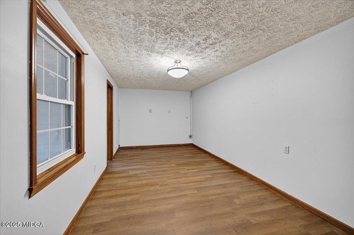 5682 Hartley Bridge Road Macon, GA 31216 - Photo 18 of 79 a view of an empty room with wooden floor and a window