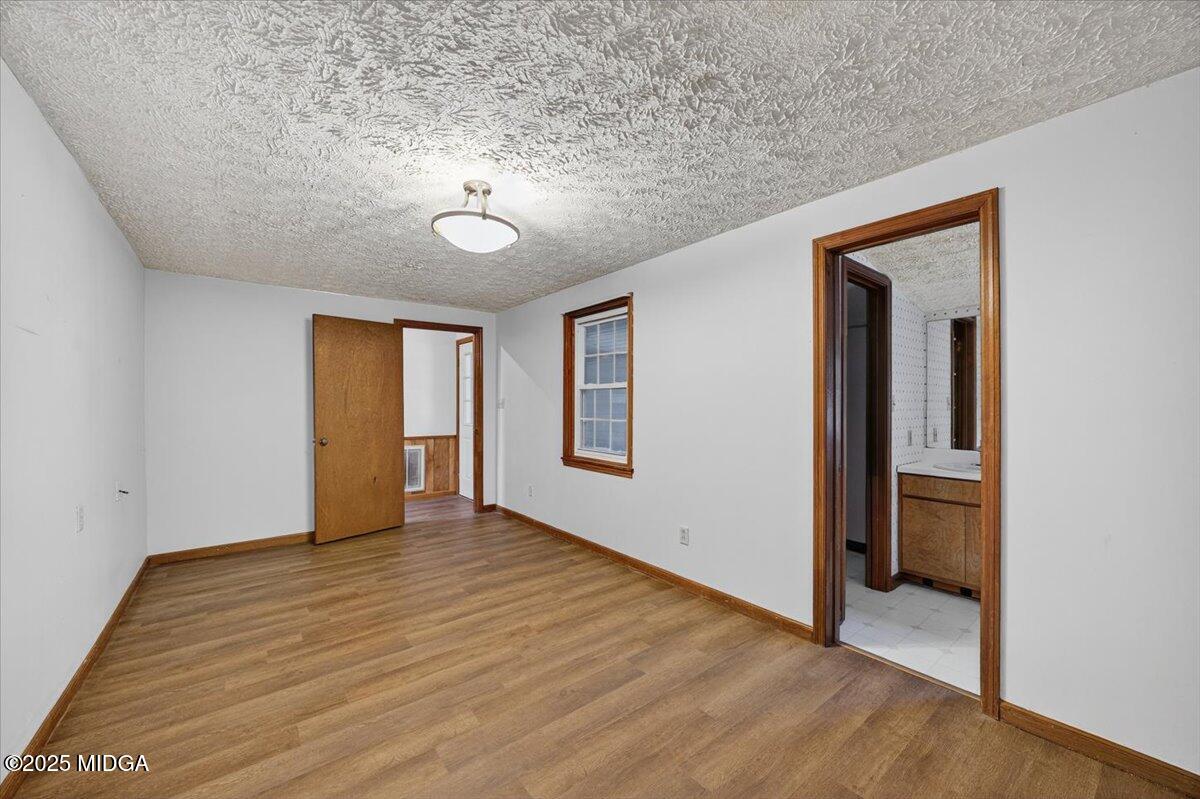 5682 Hartley Bridge Road Macon, GA 31216 - Photo 19 of 79 an empty room with wooden floor and windows