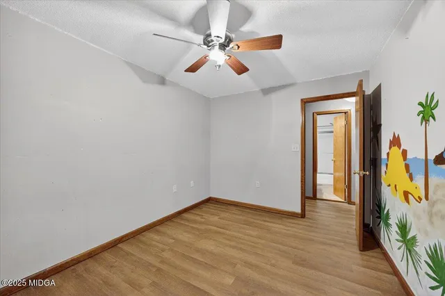 an empty room with closet and fan
