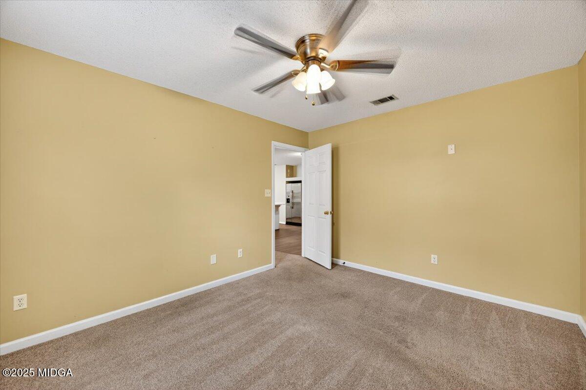5682 Hartley Bridge Road Macon, GA 31216 - Photo 30 of 79 an empty room with a ceiling fan and a window