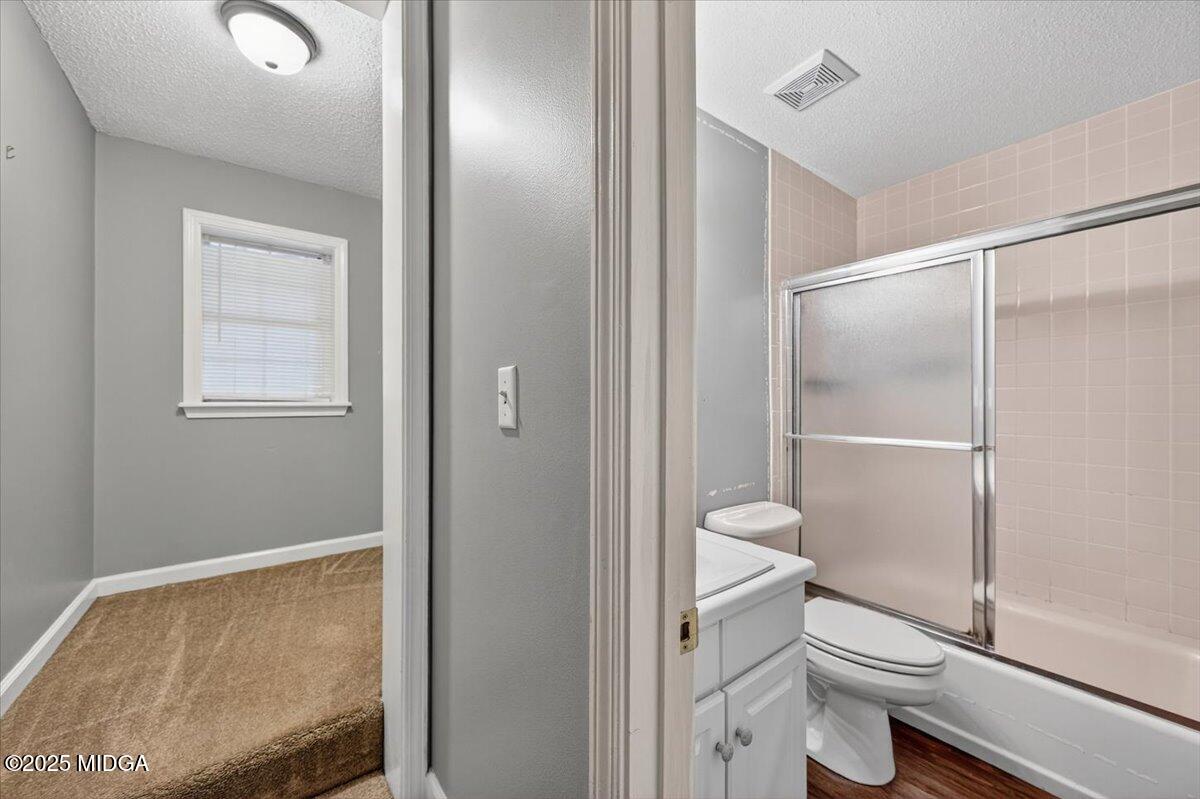 5682 Hartley Bridge Road Macon, GA 31216 - Photo 37 of 79 a bathroom with a granite countertop toilet and a shower