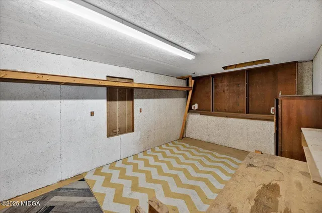 an empty room with a window and a ceiling fan