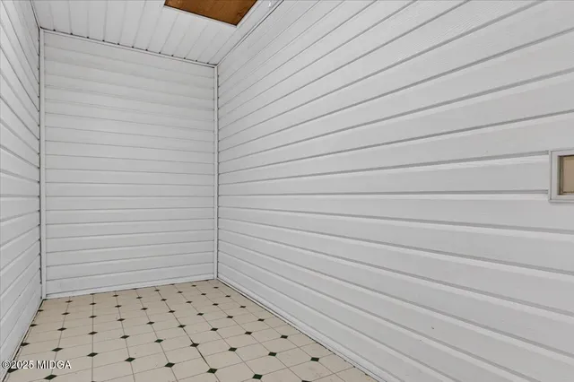 a view of empty room with wooden floor and ceiling fan