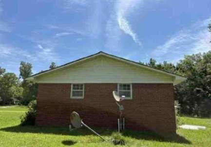 1190 Asphalt Rock Road Cherokee, AL 35616 - Photo 4 of 13 a backyard of a house with plants and a garden