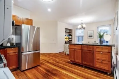 a kitchen with stainless steel appliances granite countertop a refrigerator a sink dishwasher and wooden floor
