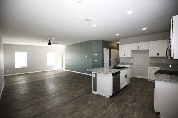 a kitchen with granite countertop white cabinets and white appliances