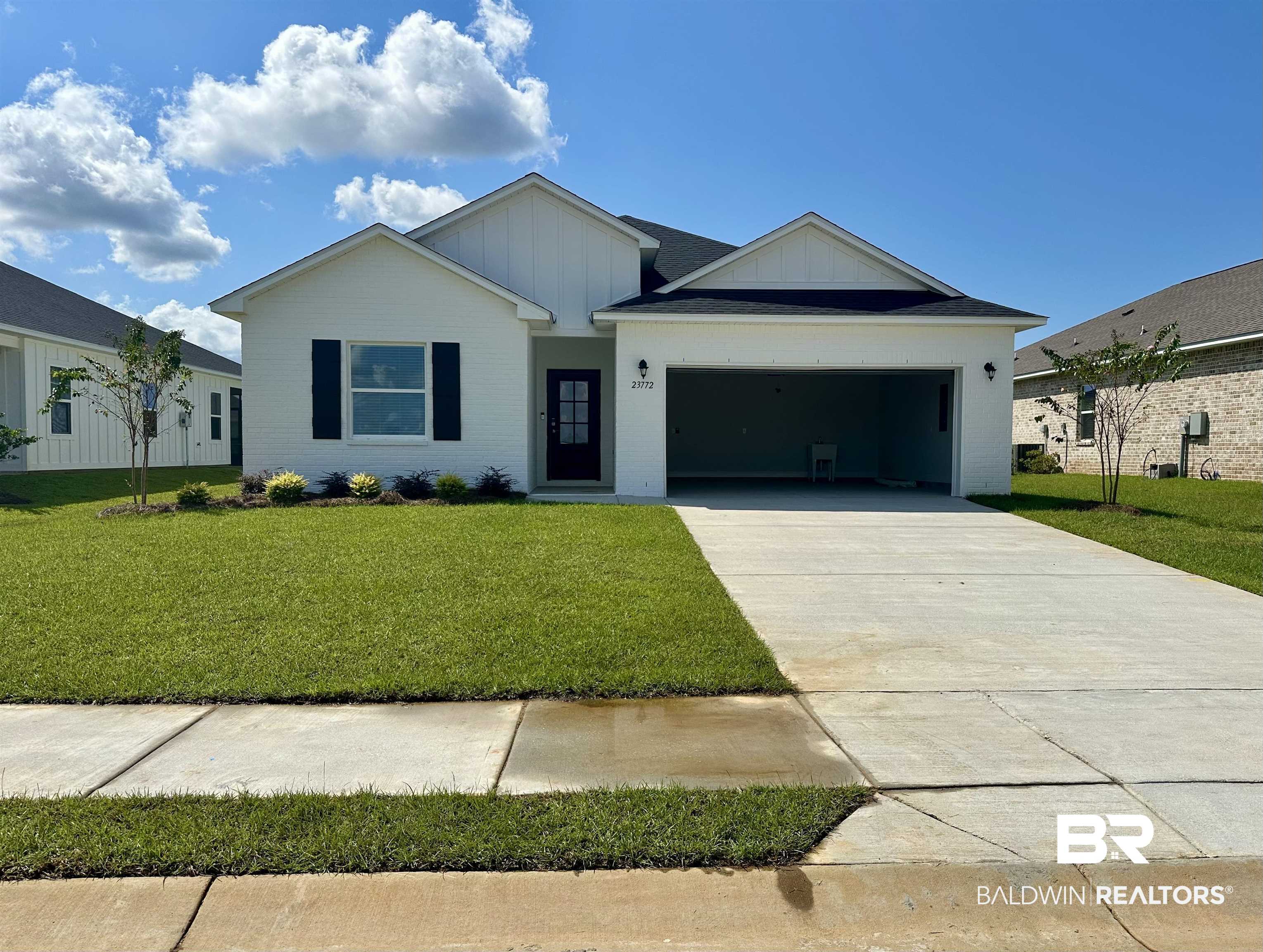 23772 Lafite Circle Daphne, AL 36526 - Photo 1 of 1 View of front of property featuring a front lawn, board and batten siding, driveway, an attached garage, and brick siding