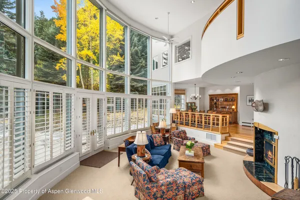 a dining room with wooden floor and large windows