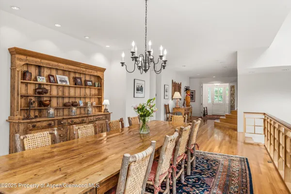 a kitchen with stainless steel appliances granite countertop a table chairs and a refrigerator