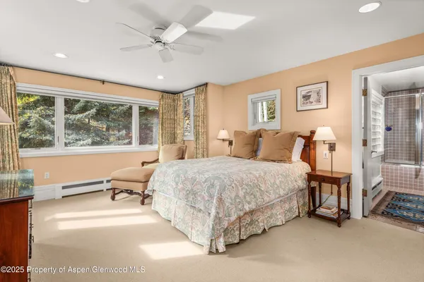 a bed sitting in a spacious bedroom next to a window