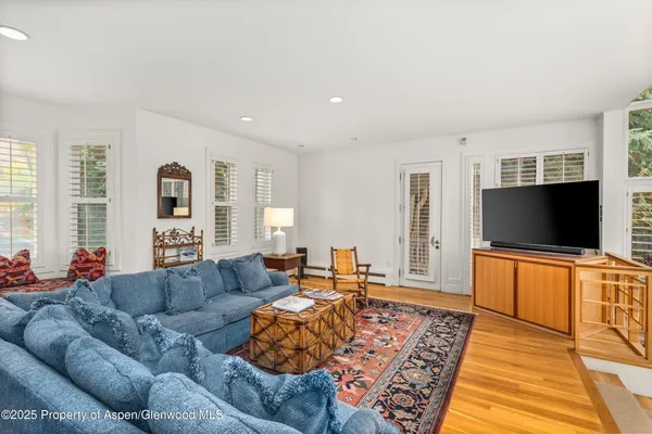 a living room with furniture flat screen tv and a large window