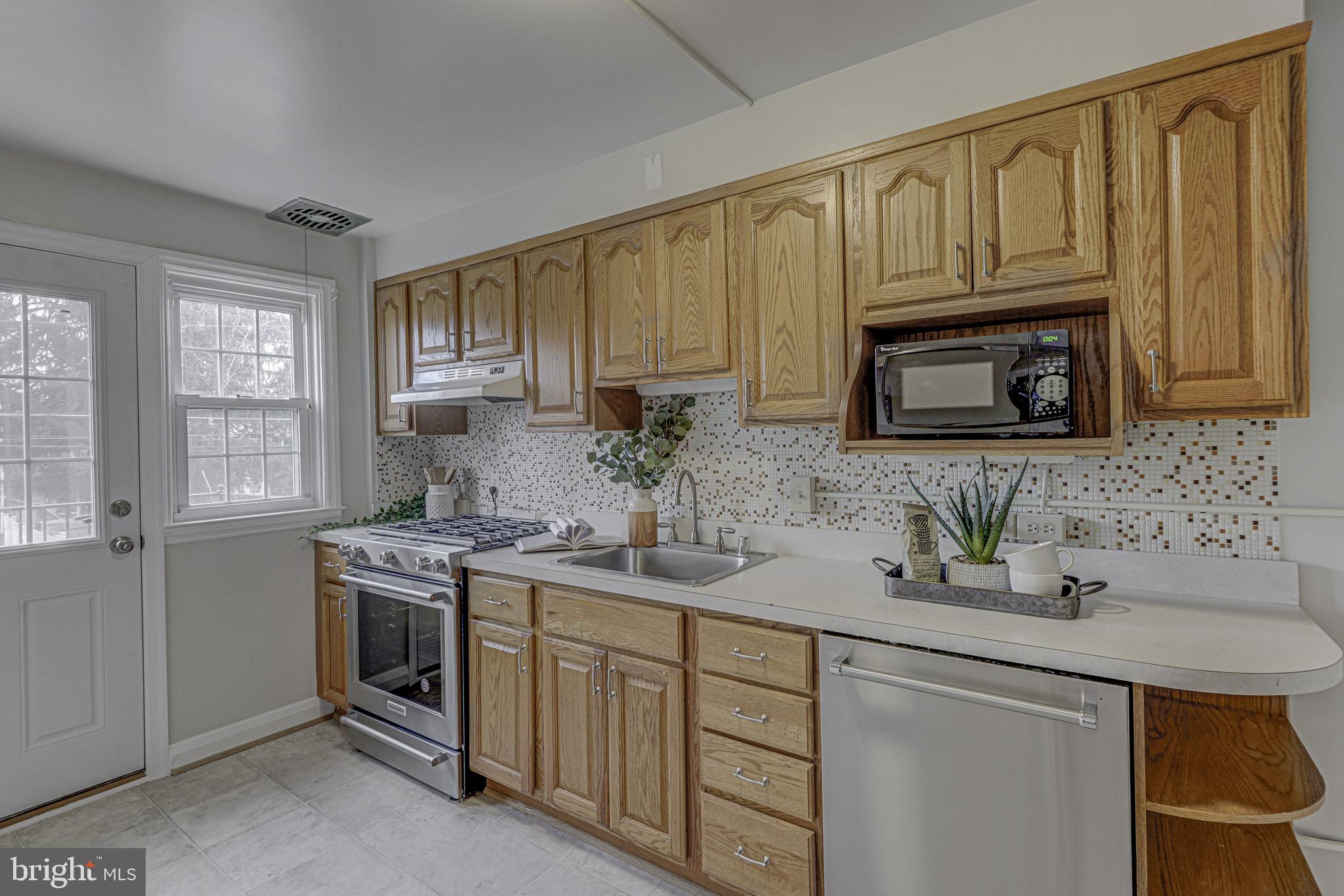 6121 Regent Park Road Baltimore, MD 21228 - Photo 14 of 36 a kitchen with stainless steel appliances granite countertop a sink stove and microwave