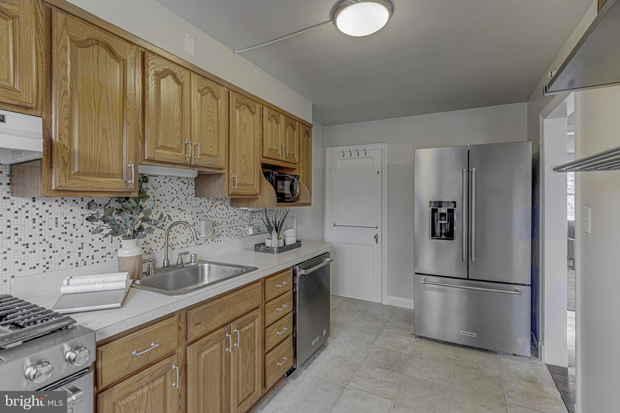 6121 Regent Park Road Baltimore, MD 21228 - Photo 16 of 36 a kitchen with stainless steel appliances granite countertop a refrigerator sink and stove