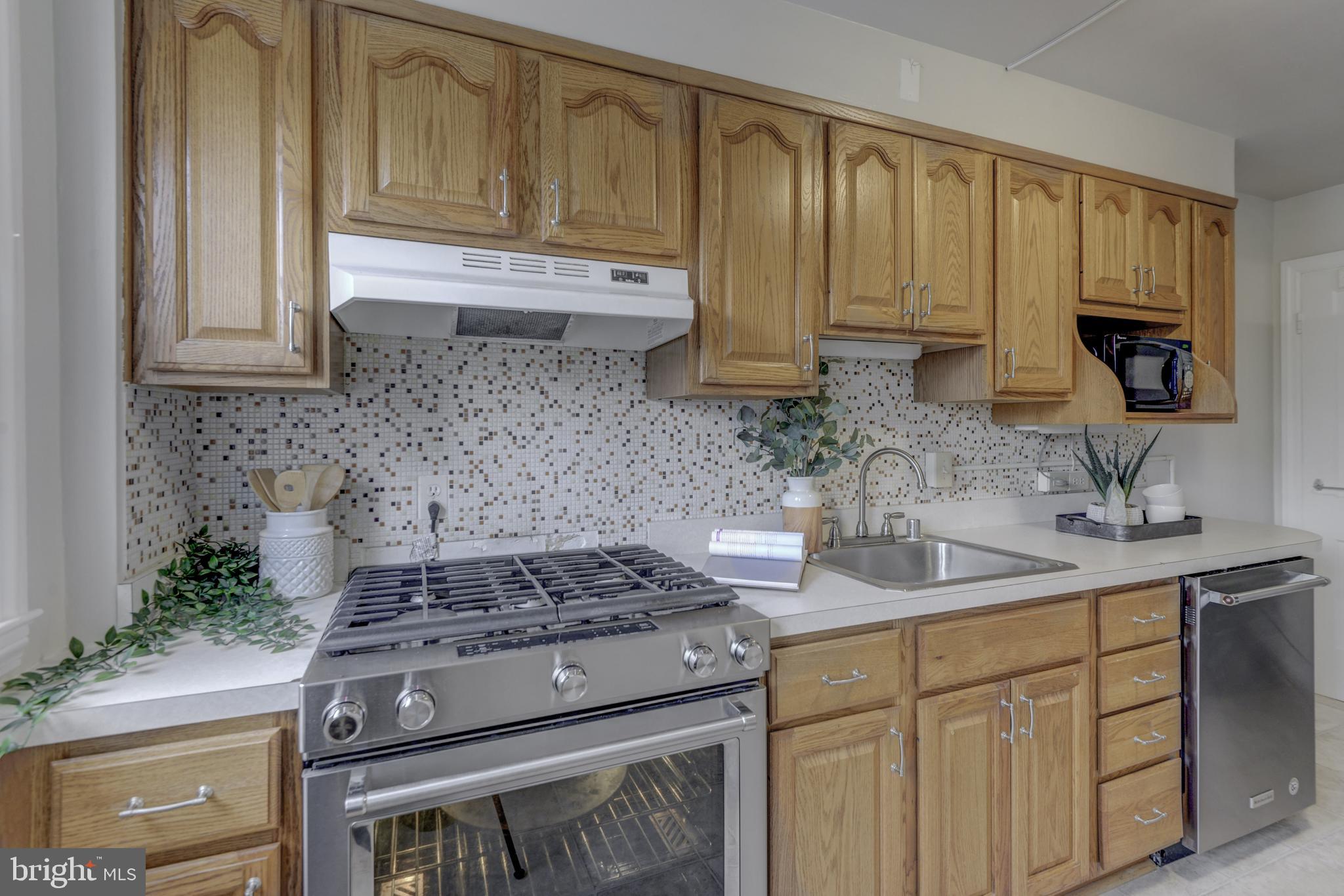 6121 Regent Park Road Baltimore, MD 21228 - Photo 17 of 36 a kitchen with stainless steel appliances granite countertop a sink stove and cabinets