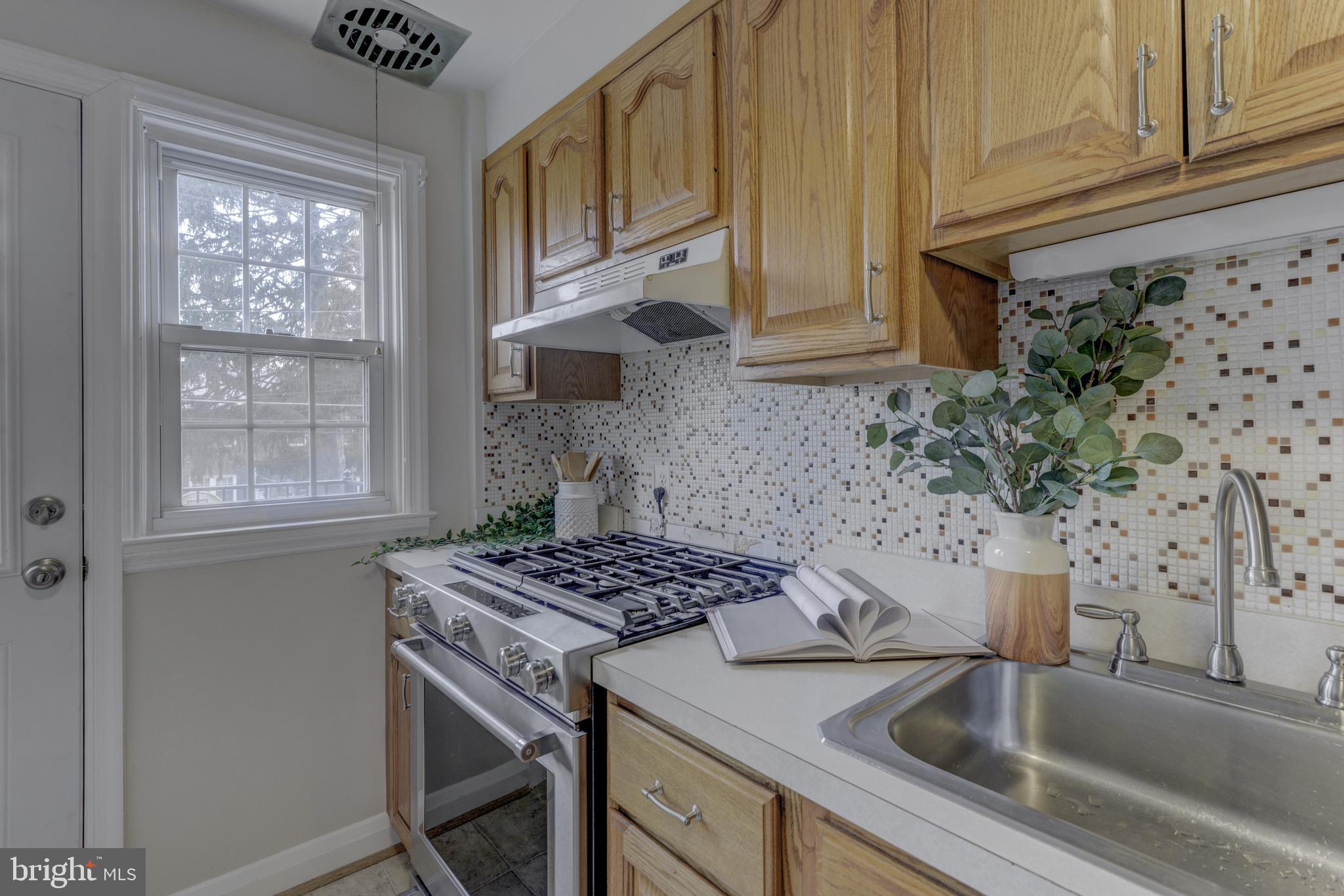 6121 Regent Park Road Baltimore, MD 21228 - Photo 18 of 36 a kitchen with stainless steel appliances granite countertop a sink stove and cabinets