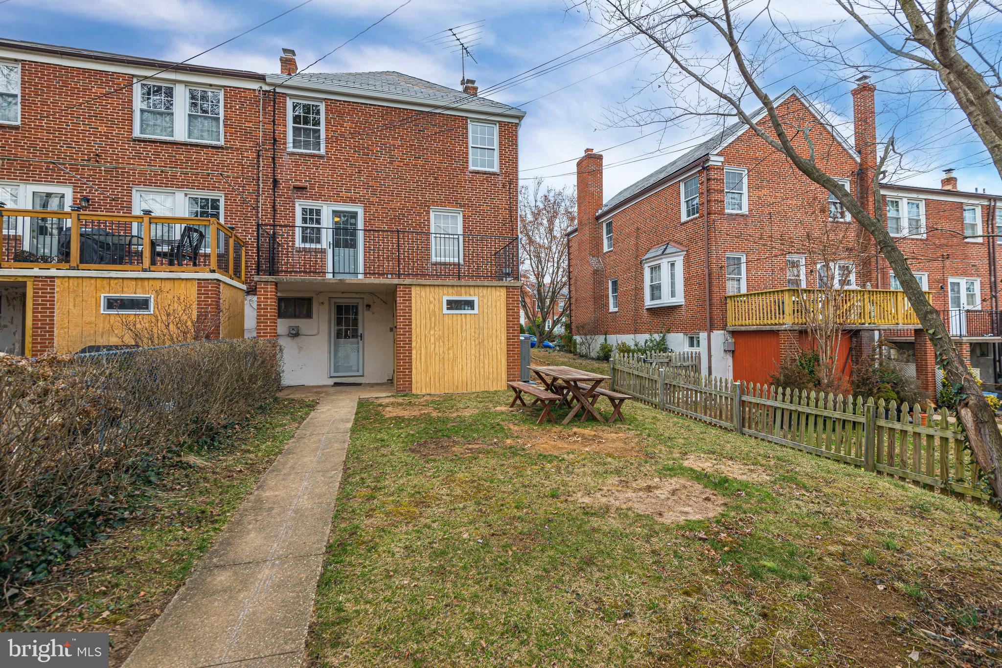 6121 Regent Park Road Baltimore, MD 21228 - Photo 35 of 36 a view of a brick house with many windows next to a yard