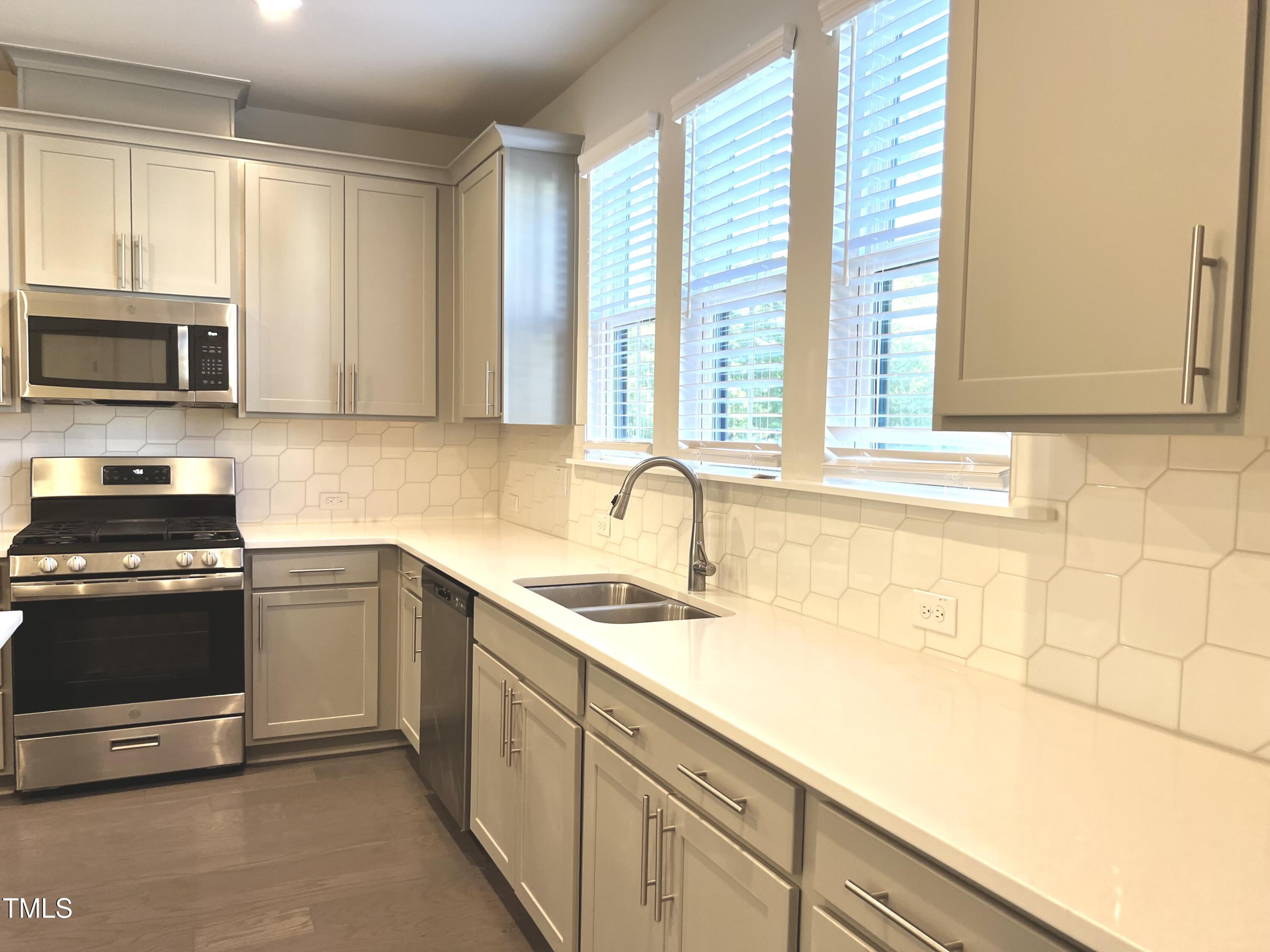 906 Waterside View Drive Raleigh, NC 27606 - Photo 12 of 27 a kitchen with stainless steel appliances granite countertop a sink and a stove