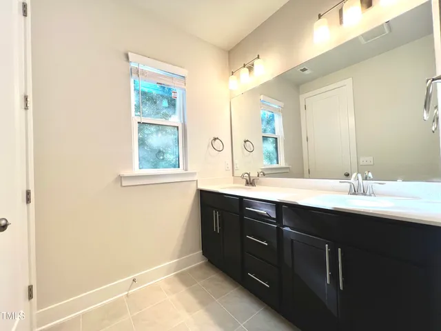 a bathroom with a sink a toilet a mirror a bathtub and shower