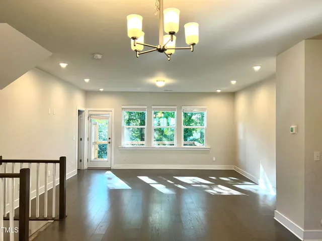 a kitchen with stainless steel appliances granite countertop a refrigerator a sink a stove and white cabinets with wooden floor