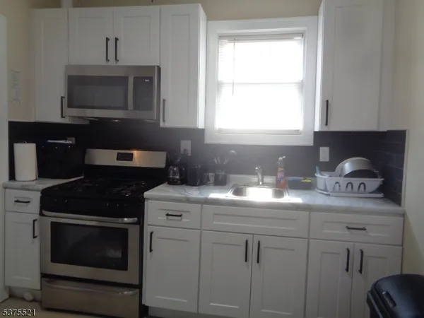 a kitchen with a sink stove and microwave