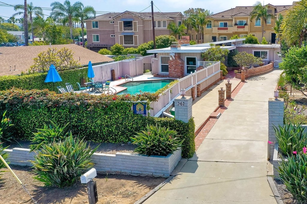 a view of a patio with couches plants and large trees