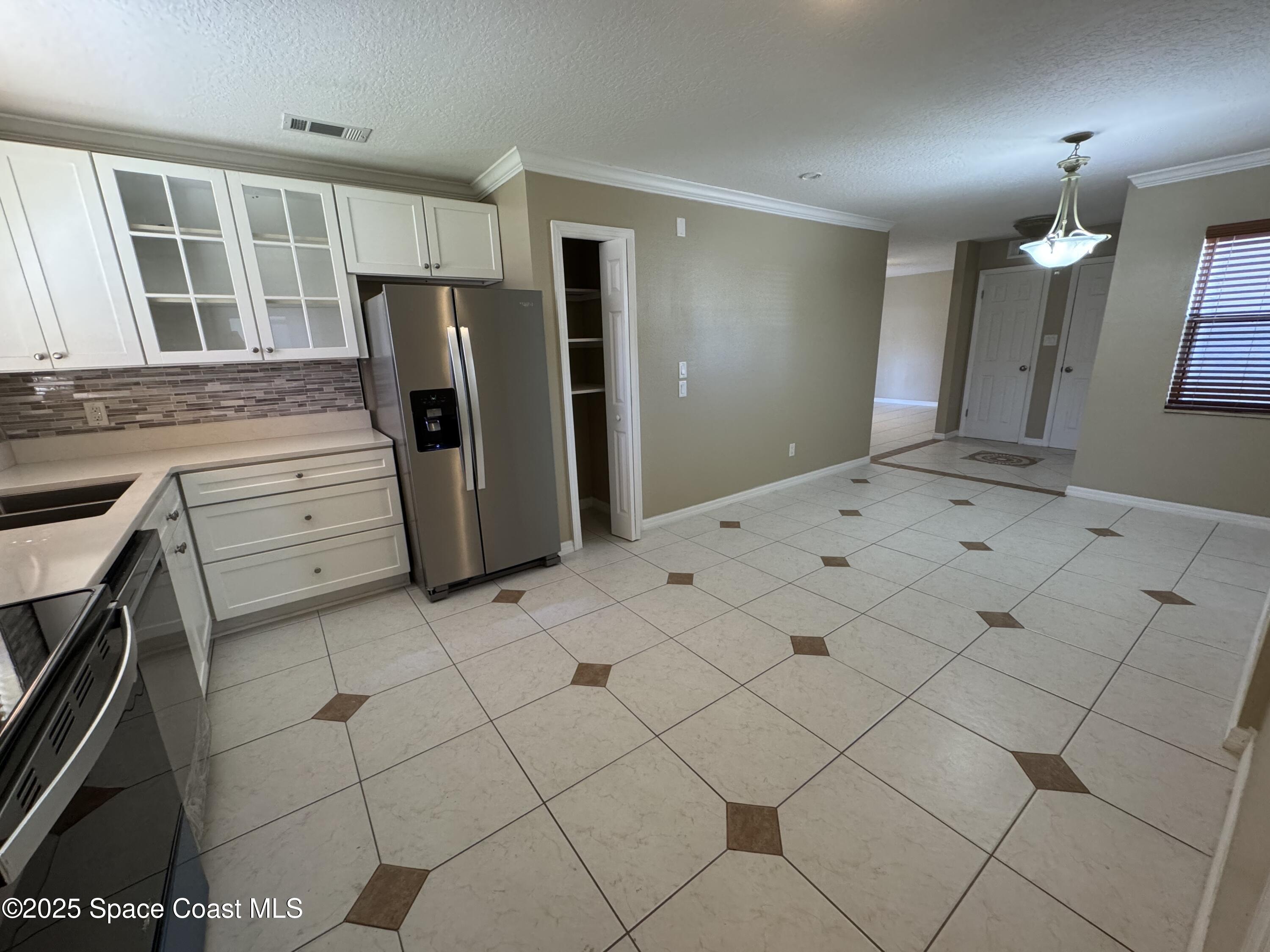 997 Beacon Road Rockledge, FL 32955 - Photo 9 of 18 a kitchen with a refrigerator a stove a sink and a counter top space