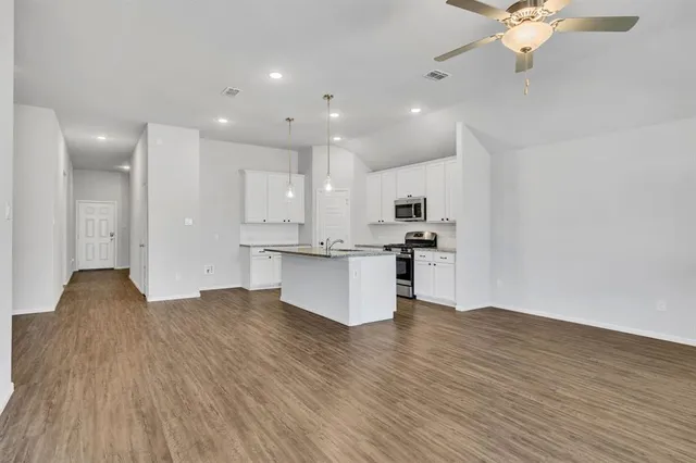 a view of kitchen with stove and cabinets