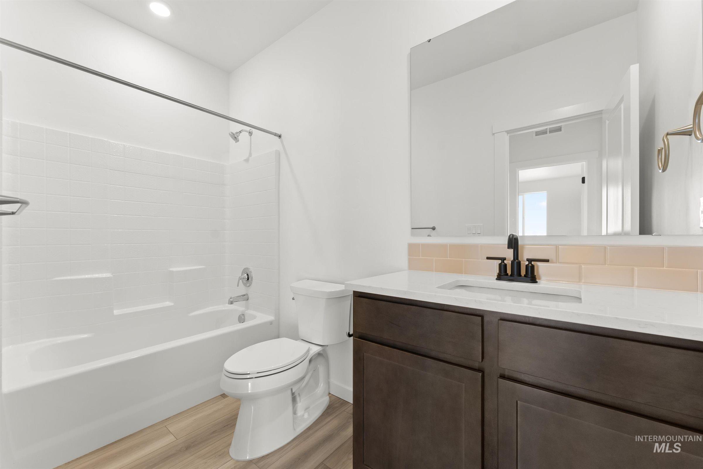 1076 East Exploration Drive Kuna, ID 83634 - Photo 10 of 29 Bathroom featuring vanity, tub / shower combination, light wood-style floors, and recessed lighting